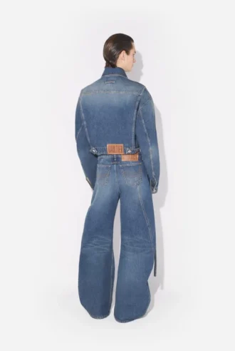 De blå denimjeansene med stropp