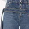 De blå denimjeansene med stropp De blå denimjeansene med stropp