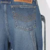 De blå denimjeansene med stropp De blå denimjeansene med stropp