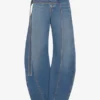 De blå denimjeansene med stropp De blå denimjeansene med stropp
