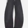 De svarte denimjeansene med stropp De svarte denimjeansene med stropp