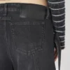 De svarte denimjeansene med stropp De svarte denimjeansene med stropp